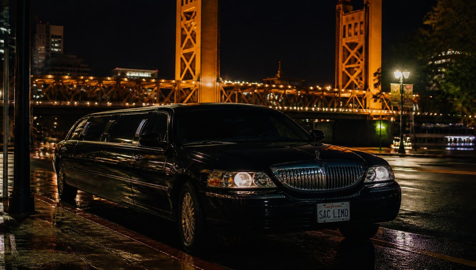 Black stretch limousine on a Sacramento street at night with Tower Bridge lit in the background